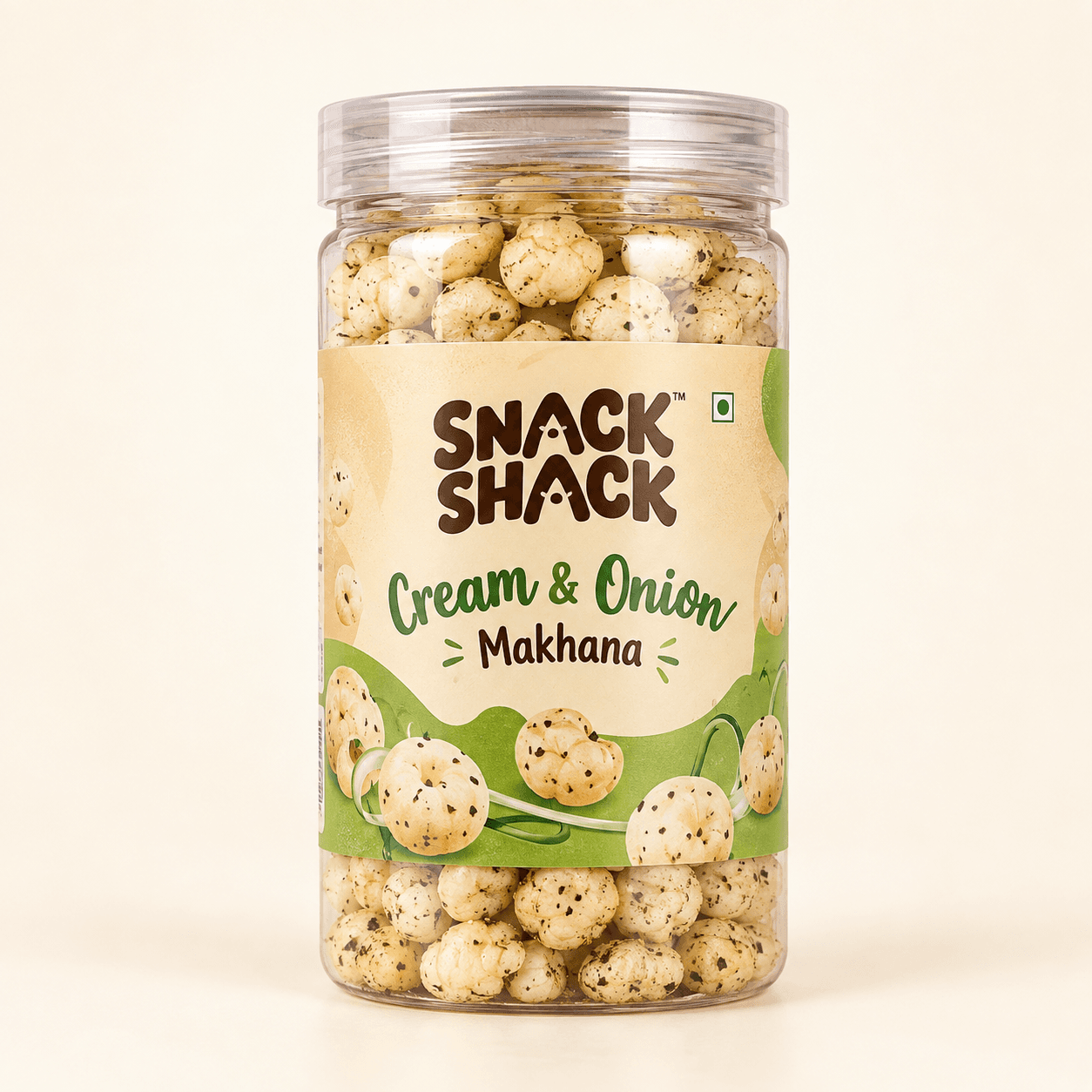 Snack Shack Cream & Onion Makhana in a transparent cylindrical jar with a clear screw-on lid, shot on a plain cream background.